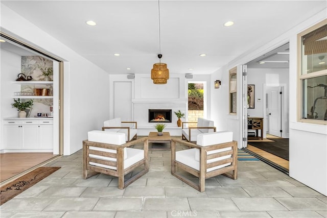 living area with recessed lighting and a warm lit fireplace