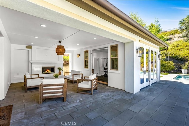 view of patio / terrace with french doors and an outdoor living space with a fireplace