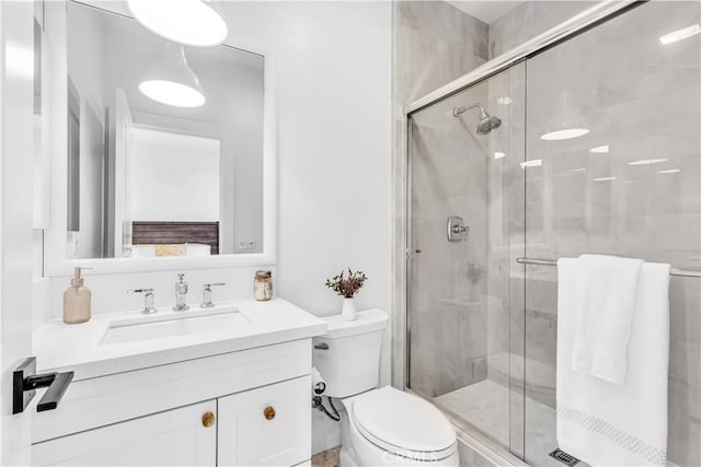 bathroom featuring toilet, a shower stall, and vanity