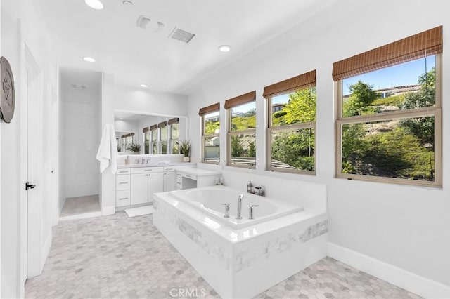 bathroom with recessed lighting, visible vents, vanity, and a bath