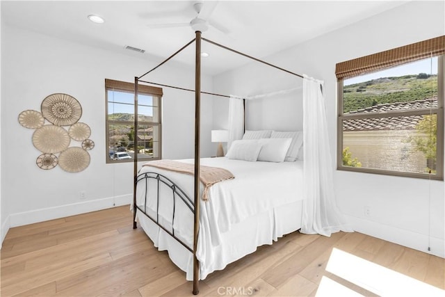 bedroom featuring light wood-type flooring, multiple windows, and visible vents