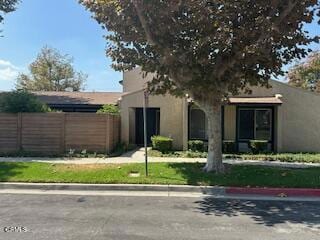 view of front of home with stucco siding and fence