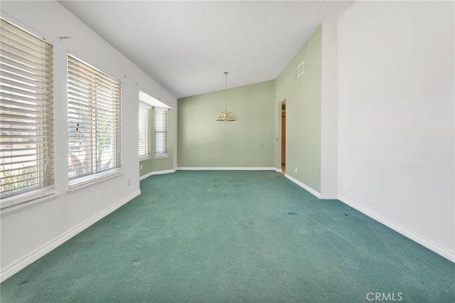 spare room with dark colored carpet, visible vents, vaulted ceiling, and baseboards