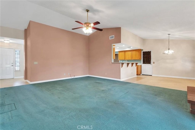 unfurnished living room featuring light carpet, baseboards, visible vents, a ceiling fan, and high vaulted ceiling