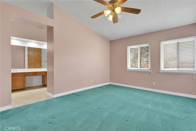 unfurnished room with light carpet, baseboards, vaulted ceiling, and built in study area