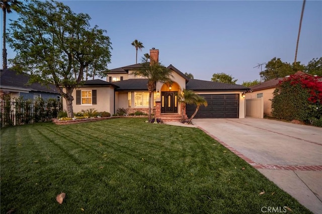 view of front of home featuring a garage, a lawn, concrete driveway, and fence