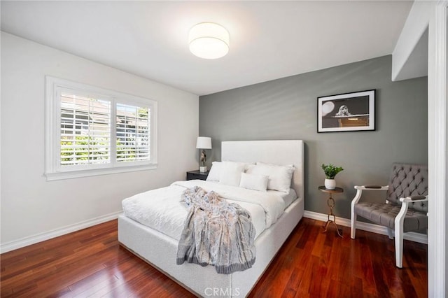 bedroom featuring wood finished floors and baseboards
