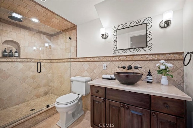 bathroom with tile walls, toilet, and a stall shower