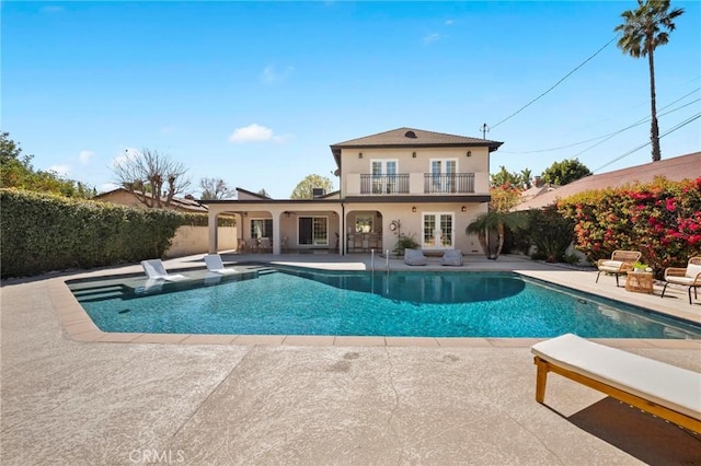 view of pool with a patio, a fenced in pool, and french doors