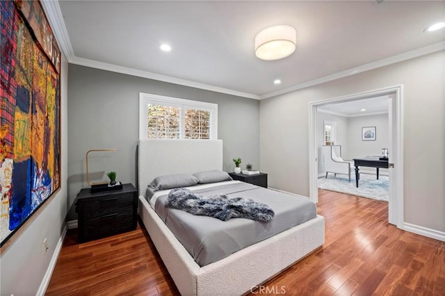 bedroom with baseboards, crown molding, wood finished floors, and recessed lighting