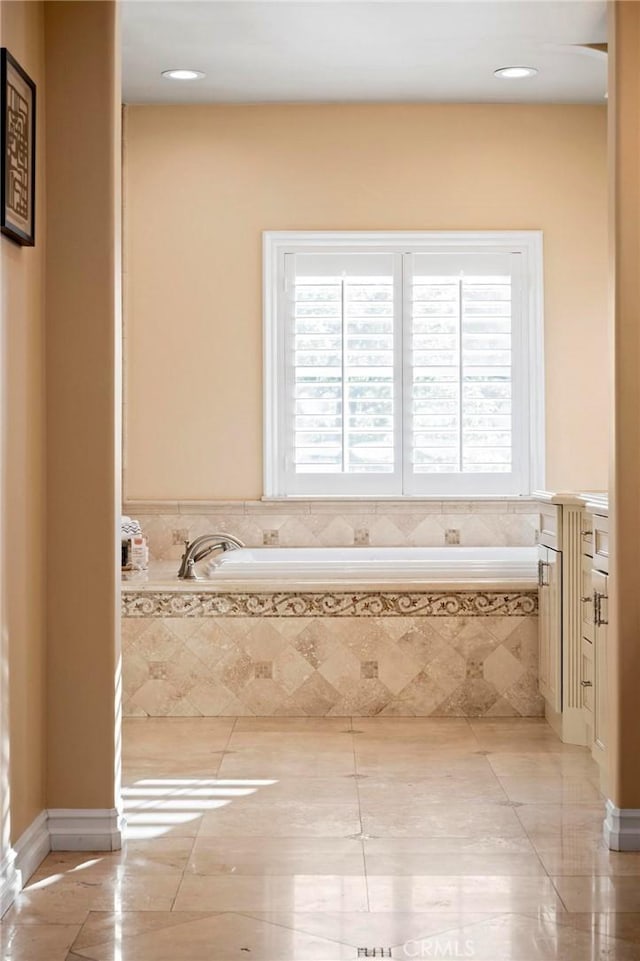 full bath with plenty of natural light, a garden tub, and tile patterned floors