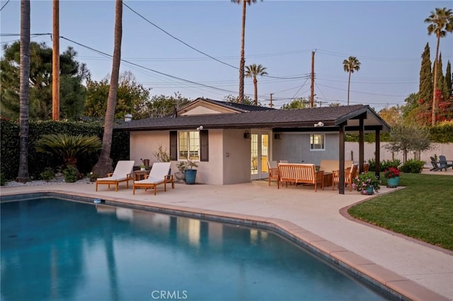 back of property with a patio, a fenced in pool, french doors, and stucco siding