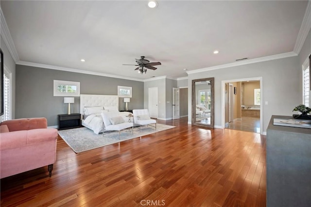 bedroom featuring baseboards, wood finished floors, multiple windows, and visible vents