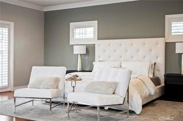 bedroom with multiple windows, crown molding, and wood finished floors