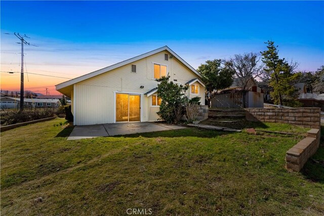 21013 Carriage Dr, Tehachapi, CA 93561 - back of house at dusk featuring a yard and a patio