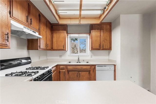 21013 Carriage Dr, Tehachapi, CA 93561 - kitchen with light countertops, white dishwasher, under cabinet range hood, and gas range
