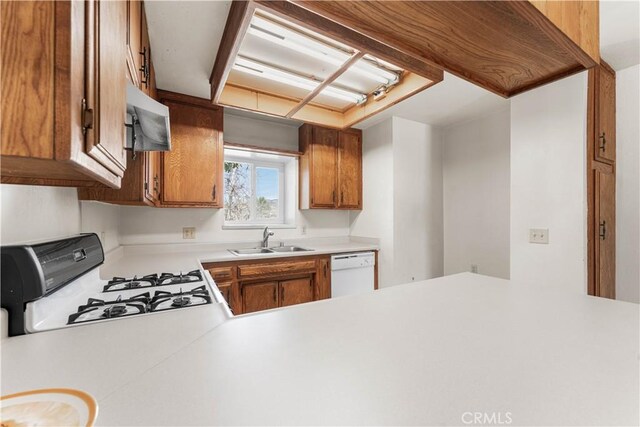 21013 Carriage Dr, Tehachapi, CA 93561 - kitchen with a peninsula, white appliances, a sink, light countertops, and brown cabinets