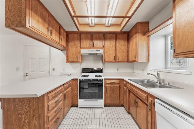 21013 Carriage Dr, Tehachapi, CA 93561 - kitchen with white appliances, brown cabinetry, light countertops, under cabinet range hood, and a sink