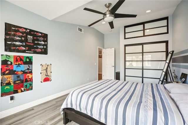 bedroom with lofted ceiling, visible vents, ceiling fan, wood finished floors, and baseboards