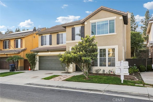 townhome / multi-family property with a garage, concrete driveway, and stucco siding