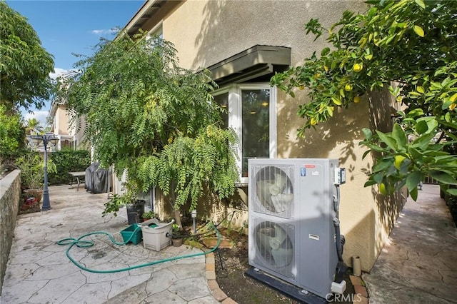 exterior space featuring ac unit, fence, and stucco siding