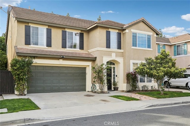 view of front of home with a garage, concrete driveway, and stucco siding