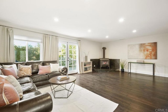 living area with baseboards, dark wood finished floors, a wood stove, and recessed lighting