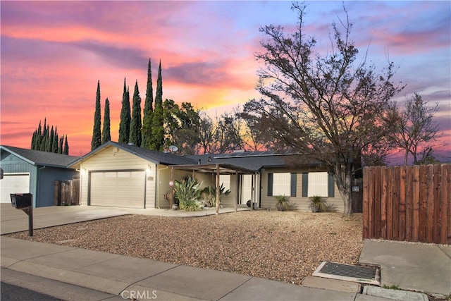 view of front of property with a garage, concrete driveway, and fence