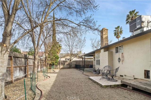 view of yard featuring a patio area, a fenced backyard, a deck, and central AC unit