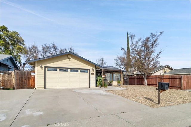 ranch-style home with driveway, a garage, fence, and a gazebo