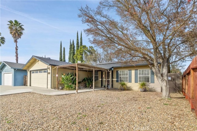 ranch-style house with an attached garage, fence, and concrete driveway