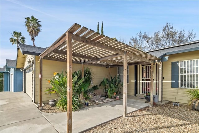 exterior space with a garage, driveway, and a pergola