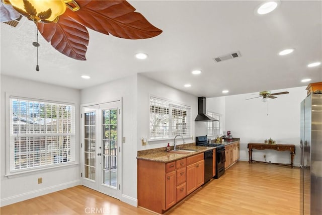 kitchen with a sink, wall chimney range hood, freestanding refrigerator, dishwasher, and gas stove