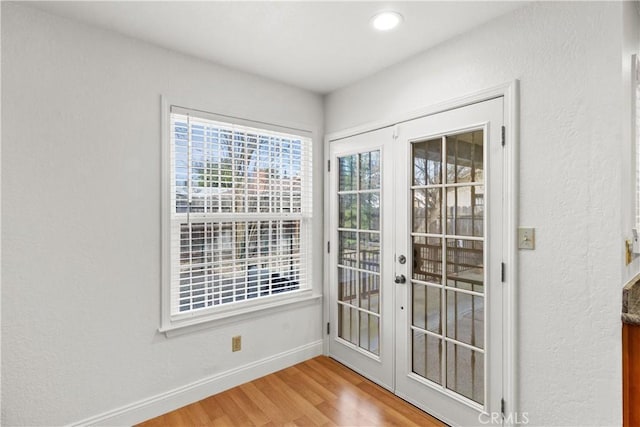 entryway with french doors, baseboards, and wood finished floors