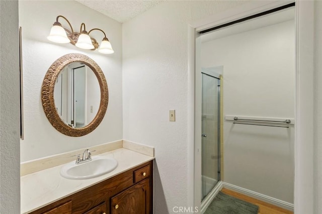 2655 Marseille Way, Stockton, CA 95209 - bathroom with a shower stall, vanity, wood finished floors, and a textured ceiling