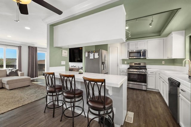 kitchen featuring stainless steel appliances, white cabinets, and light countertops