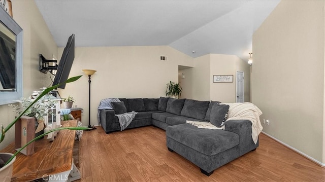 living room featuring lofted ceiling, wood finished floors, visible vents, and baseboards