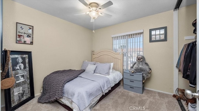 carpeted bedroom with ceiling fan and baseboards