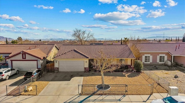 ranch-style house with a garage, a tile roof, and fence