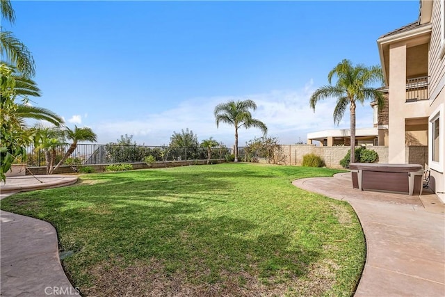 view of yard with a patio, a hot tub, and a fenced backyard