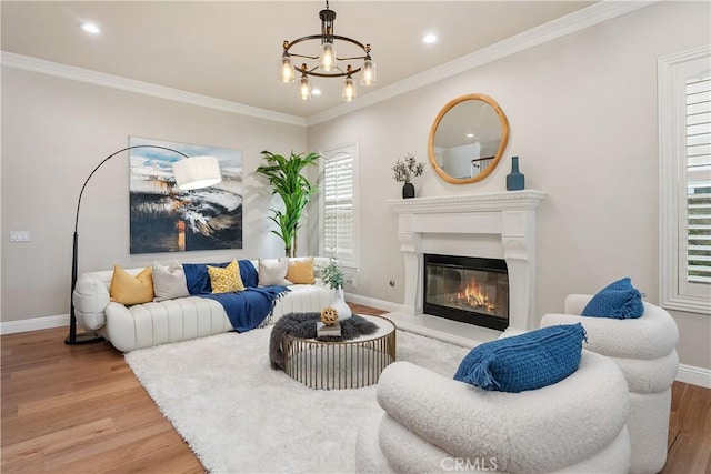 living area with plenty of natural light, baseboards, light wood-style floors, and ornamental molding