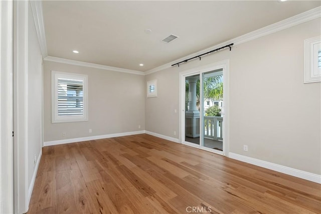 empty room featuring light wood-style flooring, a healthy amount of sunlight, baseboards, and ornamental molding