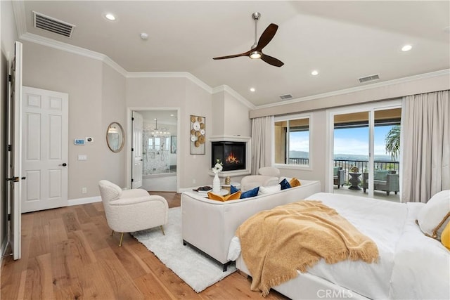 bedroom with visible vents, lofted ceiling, light wood-style floors, and crown molding