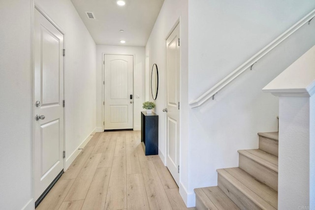 corridor with baseboards, visible vents, stairs, light wood-style floors, and recessed lighting