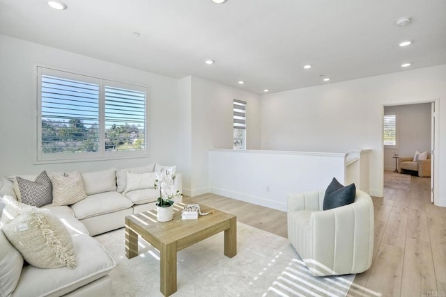 living room featuring baseboards, light wood finished floors, and recessed lighting