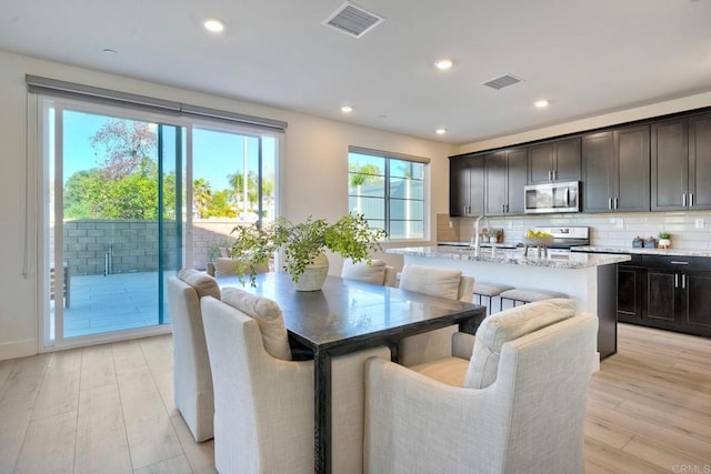 dining room with light wood-type flooring, visible vents, and recessed lighting