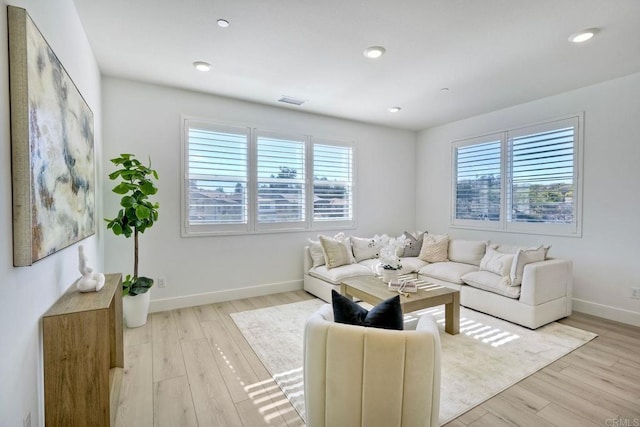 living room featuring recessed lighting, baseboards, visible vents, and light wood finished floors