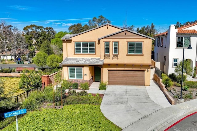 view of front of house featuring driveway, a garage, fence, and stucco siding