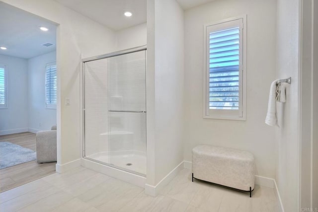 bathroom with recessed lighting, a shower stall, and baseboards