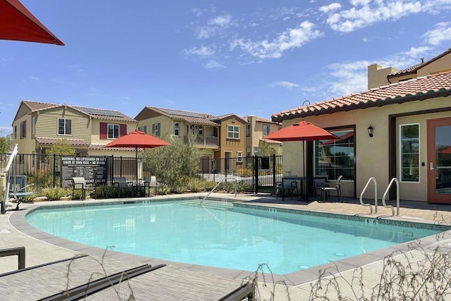 community pool with fence and a residential view